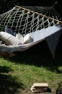 Hammock in the garden with books, pillow and blanket