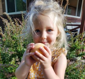 Sweet little peach Andie gets ready to sample a Palisade peach!